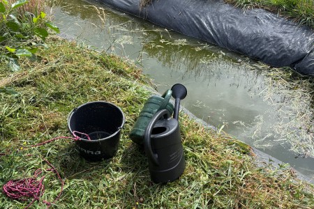 Emmer en gieter met water voor de plantjes 